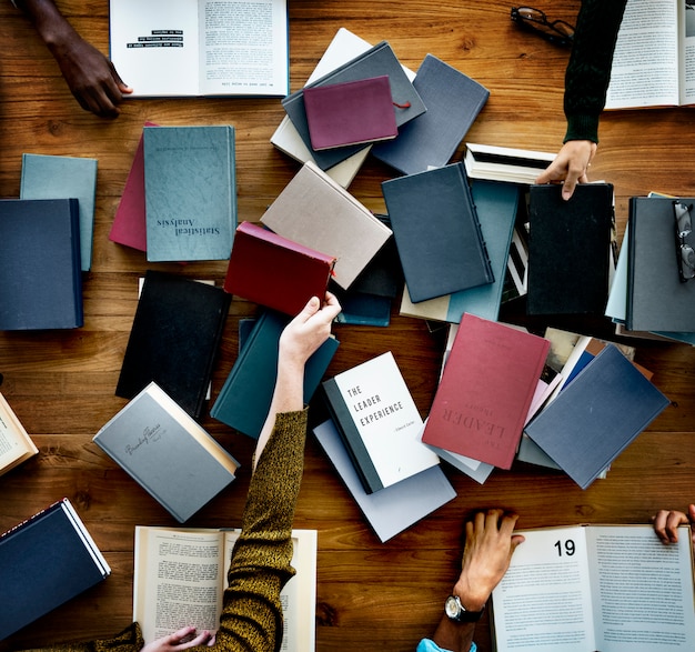 Un montón de libros sobre una mesa.