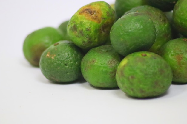 Un montón de limones verdes con la palabra aguacate en ellos.