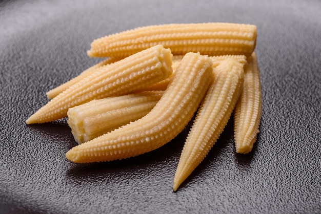 Un montón de maíz enlatado blanco pequeño sobre un fondo de hormigón oscuro