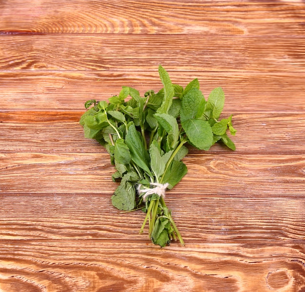 Foto montón de menta en las tablas, pared de madera