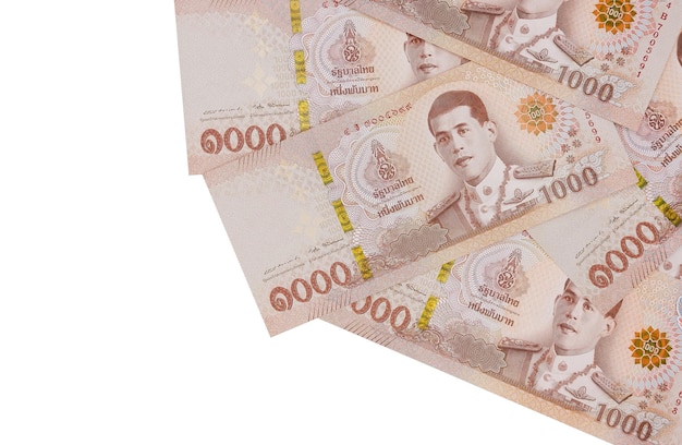 Montón de mil billetes de baht tailandés aislado sobre fondo blanco.