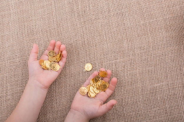 Un montón de monedas de oro falsas en la mano