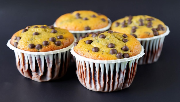 Un montón de muffins con trocitos de chocolate sobre un fondo negro