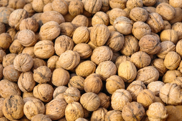 Un montón de nueces con cáscara en el mostrador del mercado