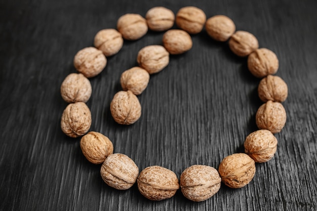 Un montón de nueces frescas sobre un fondo negro de madera. Mejores prácticas para diseñadores. Un hermoso diseño de las nueces