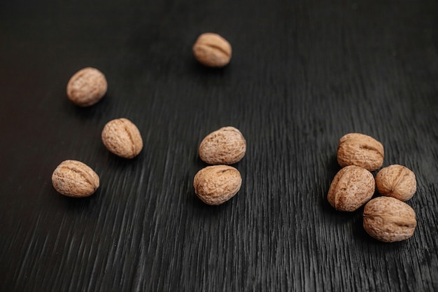 Un montón de nueces frescas sobre un fondo negro de madera. Mejores prácticas para diseñadores