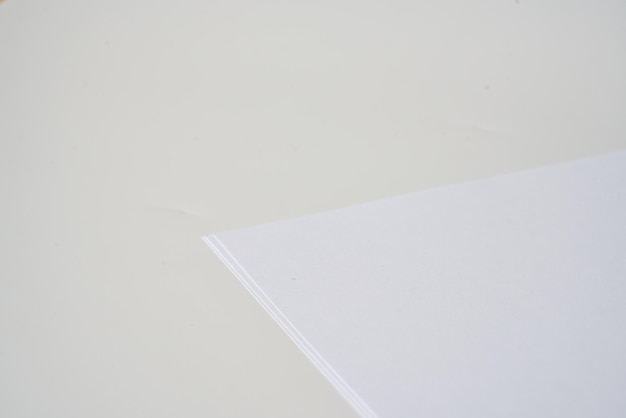 Foto montón de papel a4 blanco y en blanco sobre una superficie blanca