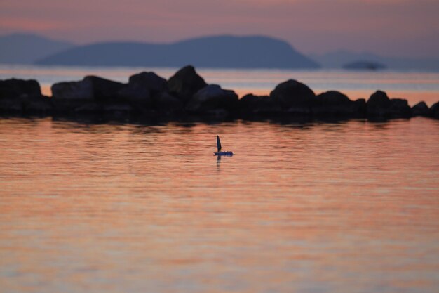 Un montón de pequeños barcos de papel al atardecer