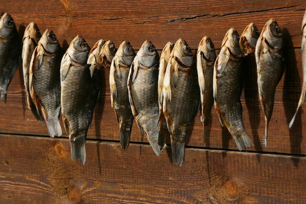 Un montón de pescado salado seco cuelga sobre un fondo de tablones de madera