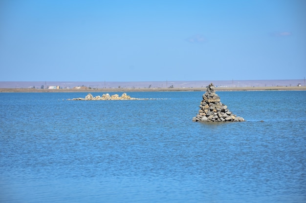 Montón de piedras en medio del agua un mojón en el lago