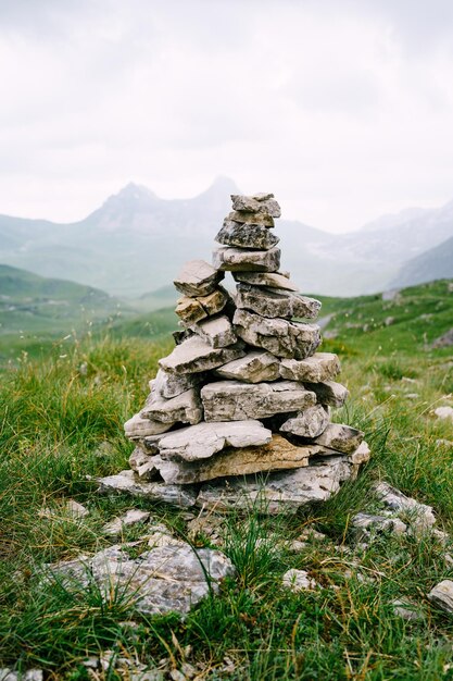 Montón de piedras sobre un césped verde en lo alto de las montañas