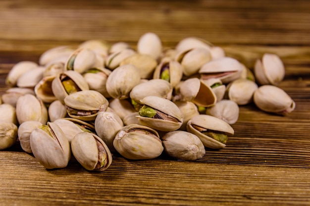 Montón de pistachos en una mesa de madera