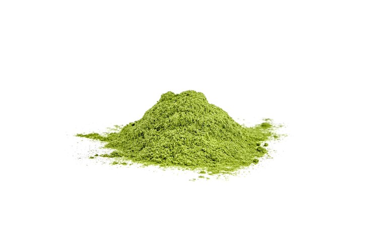 Montón de polvo de pasto de trigo liofilizado verde aislado en blanco