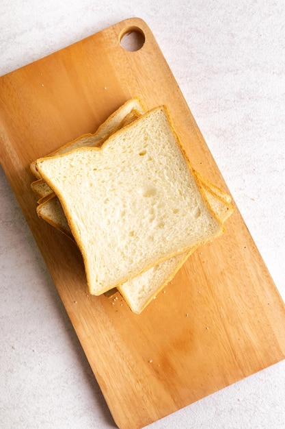 Montón de rebanadas de pan tostado en la tabla de cortar para el desayuno Fondo brillante aislado