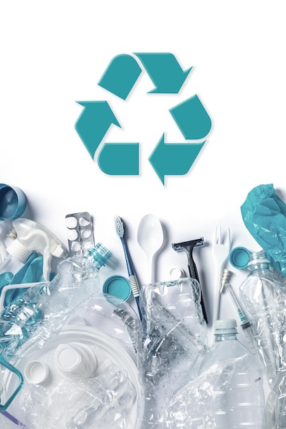 Montón de residuos plásticos y símbolo de reciclaje.