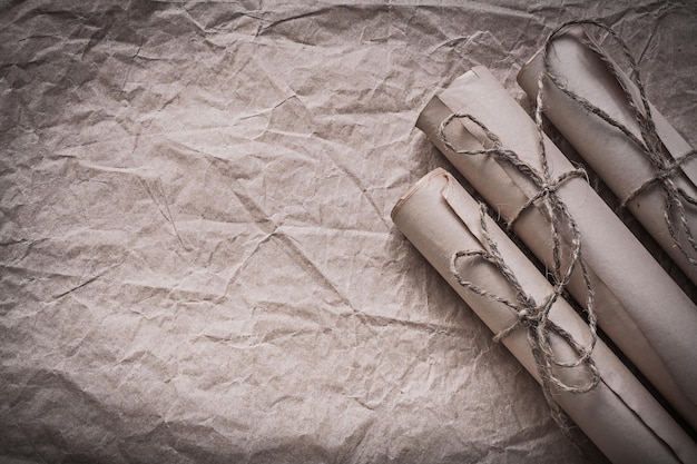 Montón de rollos de papel vintage en una hoja de envoltura arrugada