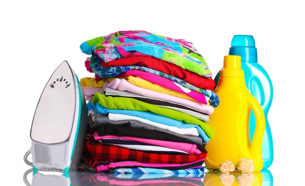 Foto montón de ropa colorida y plancha eléctrica con detergente aislado en blanco
