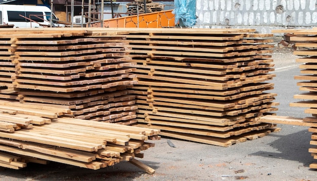 Montón de tablones de madera apilados en un sitio de construcción