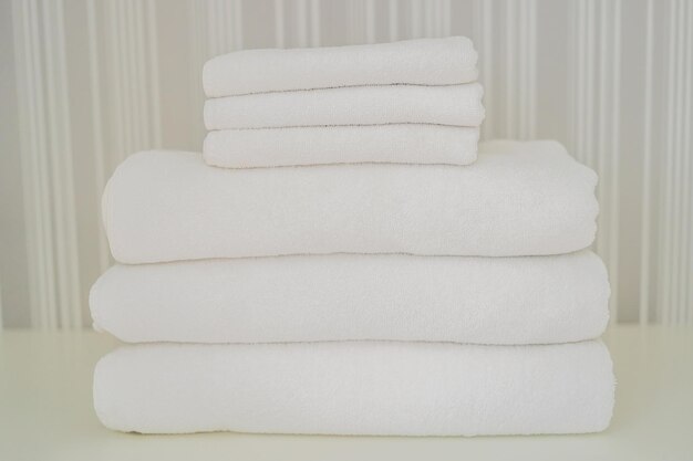 Un montón de toallas blancas esponjosas en el armario Servicio en el concepto de lavandería del hotel