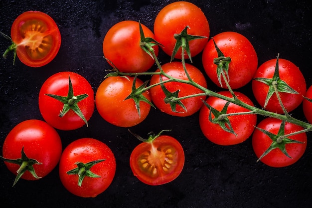Un montón de tomates cherry orgánicos frescos sobre un fondo oscuro