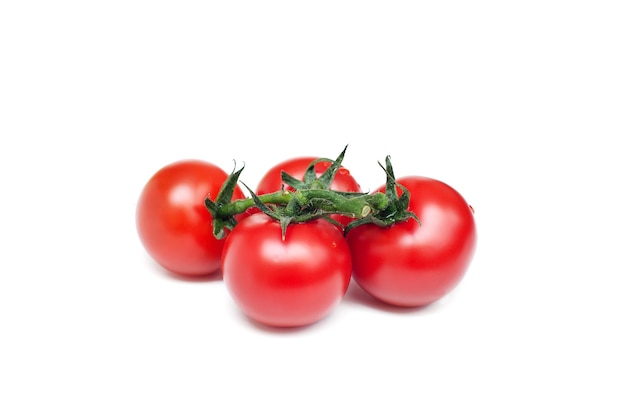 Montón de tomates frescos y rojos sobre fondo blanco.