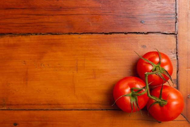 Montón de tomates en la mesa de madera con espacio negativo en el spa negativo de fondo de madera de tomates izquierdos