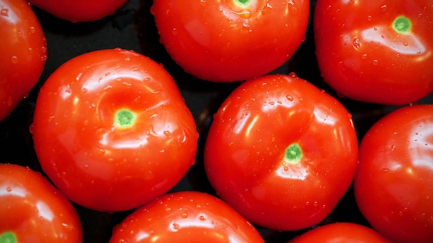 un montón de tomates rojos están en una pila