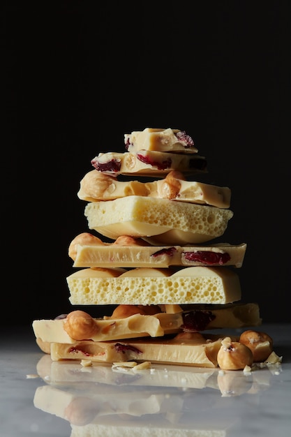 Montón de trozos de chocolate blanco con gotas de chocolate sobre un fondo de mármol