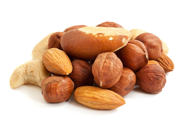 Montón de varios tipos de nueces (almendras, avellanas, anacardos, nueces de Brasil) aislado en blanco