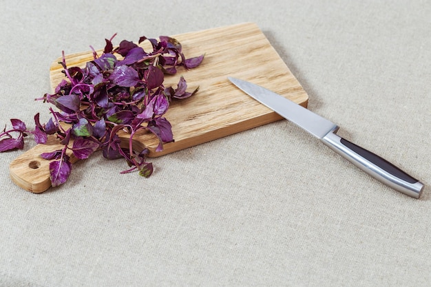 Montón de vegetación - primer plano de albahaca púrpura en el escritorio de madera. Corta las verduras. Copia espacio