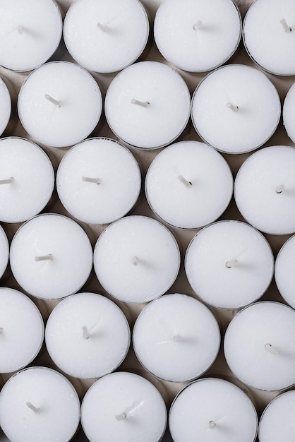 Un montón de velas blancas de tealight en el fondo a granel