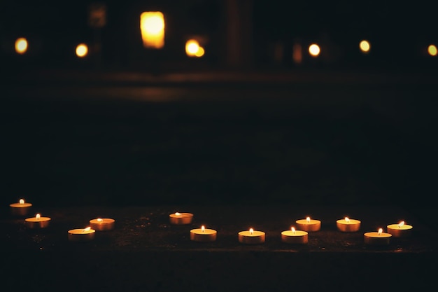 Un montón de velas encendidas en la oscuridad