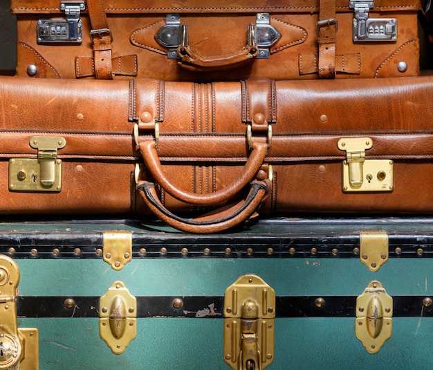 Montón de viejo equipaje vintage de cerca con un colorido baúl azul y dos maletas de cuero en un concepto de viaje