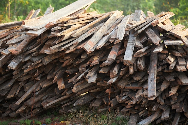 Montón de viejos tablones de madera sobre fondo de bosque verde