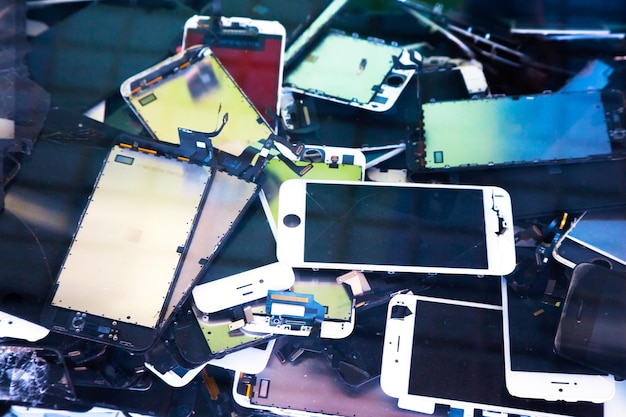 Montón de viejos teléfonos inteligentes rotos con pantalla táctil rota