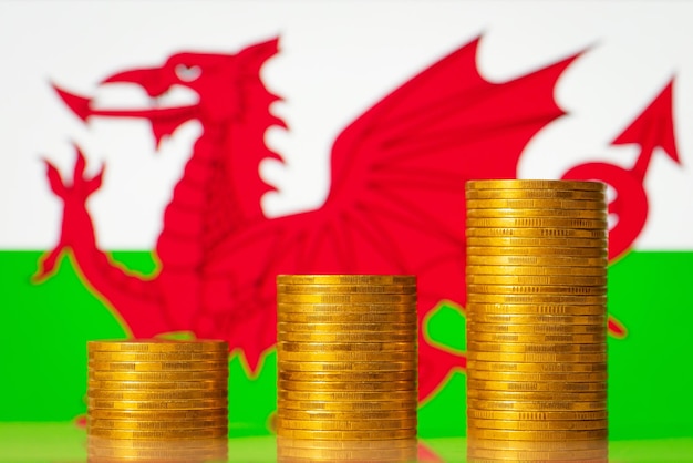Montones de dinero frente a la bandera de Gales Desarrollo financiero de Gales