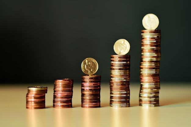 Montones de monedas de ahorro dispuestas en orden sobre una mesa de trabajo de madera o torres altas de monedas la riqueza