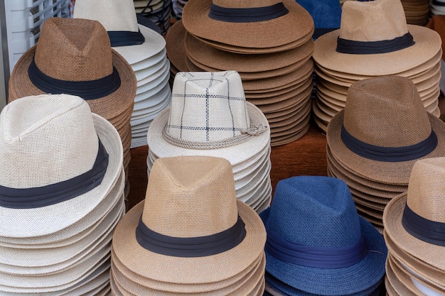 Montones de sombreros de hombre en el mostrador de la calle