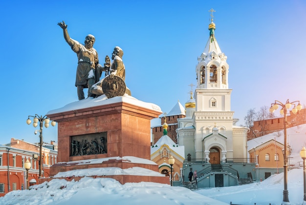 Monumento a Minin e Pozharsky e a torre do sino da Igreja perto das muralhas do Kremlin de Nizhny Novgorod