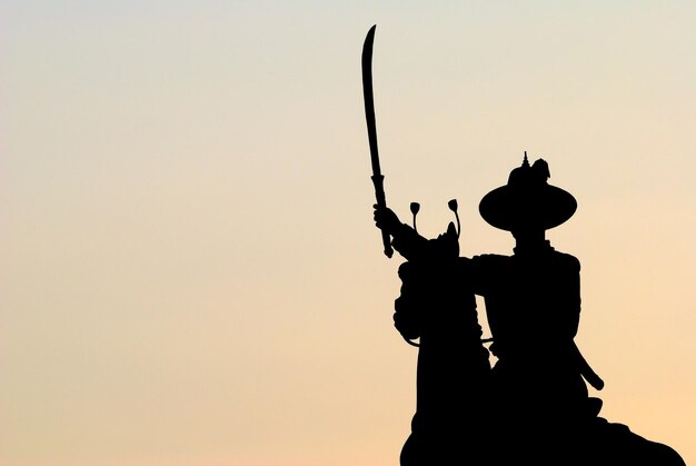 Monumento em silhueta contra o céu claro ao pôr-do-sol
