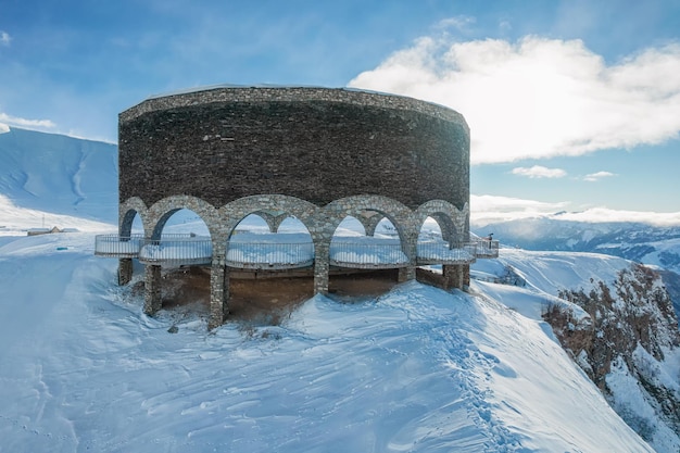 Monumento ruso a la amistad georgiana rodeado de montañas nevadas del Cáucaso Georgia