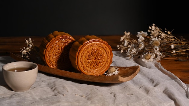 Mooncakes tradicionais em mesa de madeira com xícara de chá Mid Autumn festival ou festival tradicional chinês