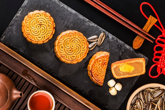 Mooncakes tradicionais na configuração de mesa com uma xícara de chá.