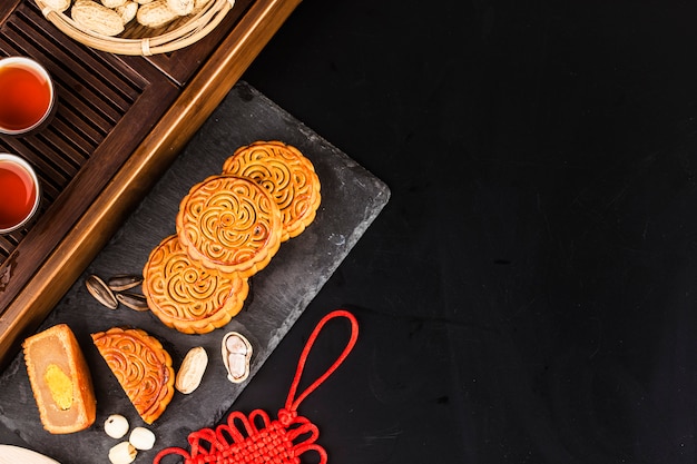 Mooncakes tradicionais na configuração de mesa com uma xícara de chá.