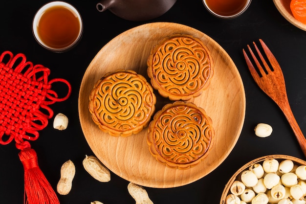 Mooncakes tradicionales en mesa con taza de té.