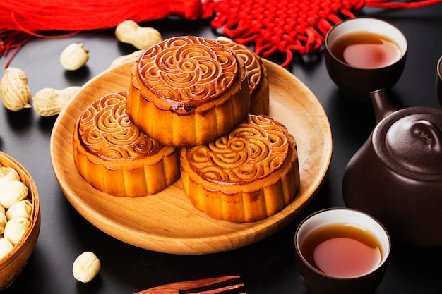 Mooncakes tradicionales en mesa con taza de té.