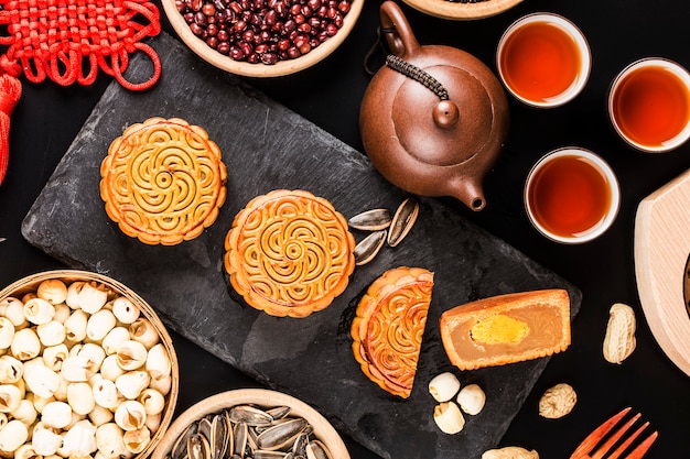 Mooncakes tradicionales en mesa con taza de té.