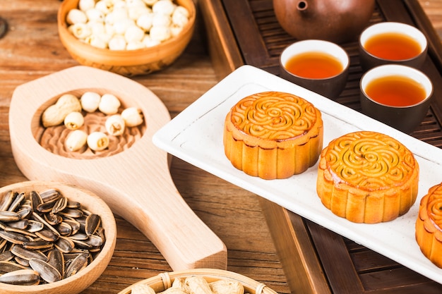 Mooncakes tradicionales en mesa con taza de té.