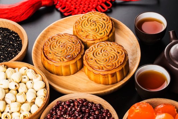 Mooncakes tradicionales en mesa con taza de té.