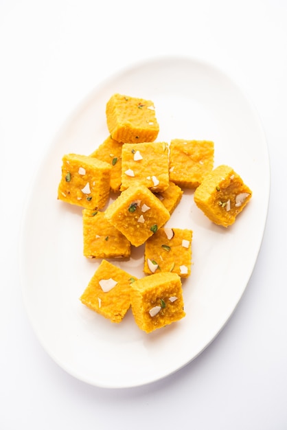 MoongÃ Dal Besan Burfi wird aus gerösteten MoongÃ Dal oder gelben Linsen, Kichererbsenmehl, Ghee, Khoya oder Mawa und Zuckersirup, indischer Süßigkeit oder Dessert hergestellt